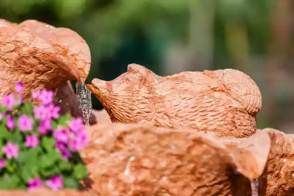 Dreistöckiger Brunnen mit Igelskulpturen aus einem naturbelassenen Kalksteinfindling