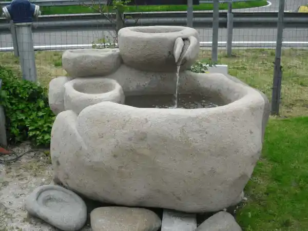 Großer Gartenbrunnen mit Quellbecken aus einem Porphyrfindling