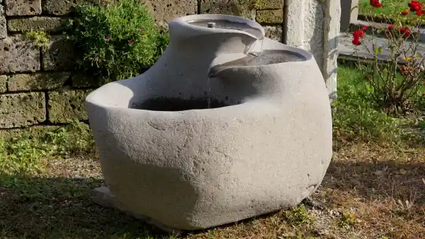 Fontana da giardino realizzata da un masso di porfido con un delicato gioco d'acqua