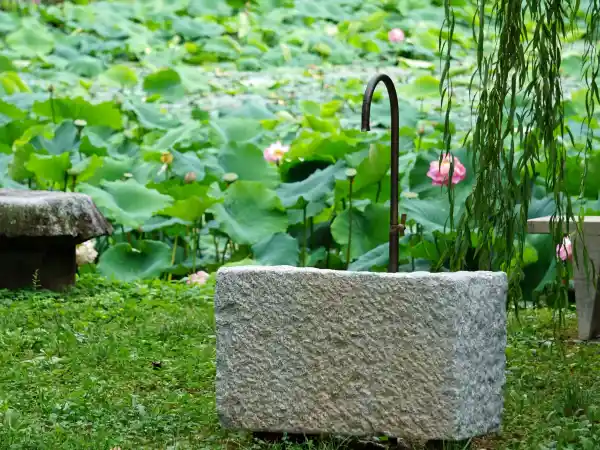 Rechteckiger Natursteinbrunnen aus weiß schwarzem Granit mit geschmiedetem Messing-Wasserhahn