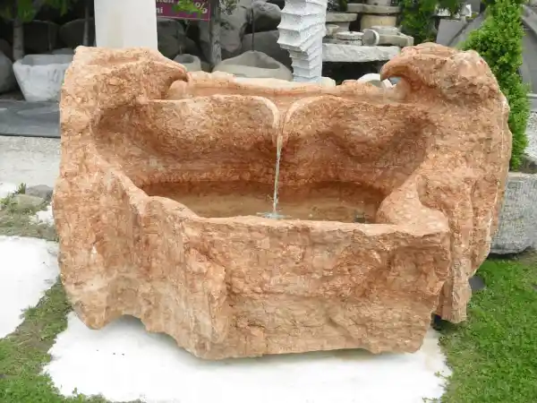 Vierstöckiger Brunnen mit Wasserspielen aus einem naturbelassenen Kalksteinfindling