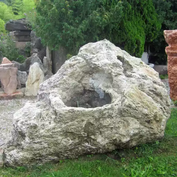 Brunnen aus einem natürlichen Steinfindling mit Wasserlauf aus hellem Kalkstein - Jacob Steinmetz Neumarkt in Südtirol