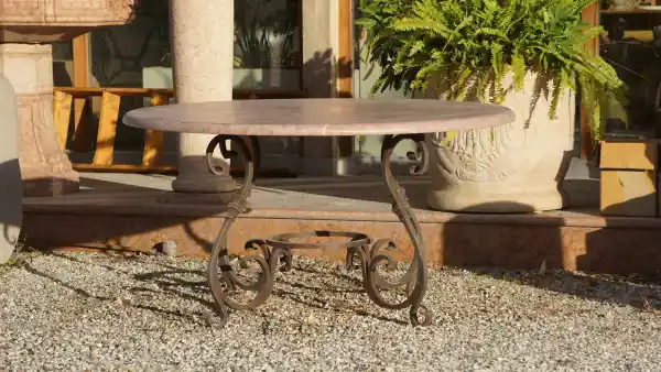 Gartentisch mit massiven Eisengestell und einer Natursteinplatte