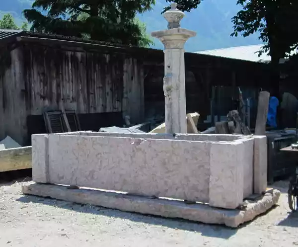Typischer historischer Brunnen aus dem Südtiroler Unterland aus rötlichem Kalkstein