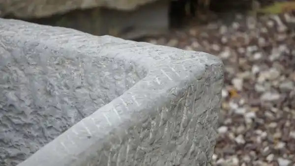 Detail der Bearbeitung des alten Futtertrogs aus Naturstein
