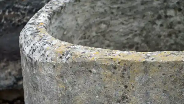 Patina auf einem alten runden Brunnen aus Kalkstein der noch mit Hand gearbeitet wurde