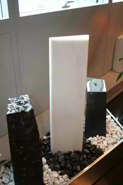 Stelen aus Stein mit Bohrung für Wasser in einem modernen Bürobrunnen