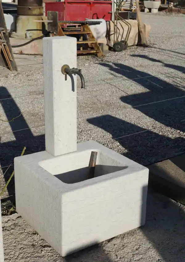 Kleiner Brunnen mit Steinsäule aus hellem Kalkstein