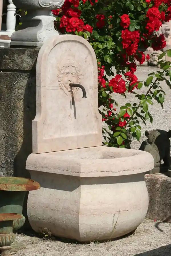 Wandbrunnen aus rosa Kalkstein mit Relief